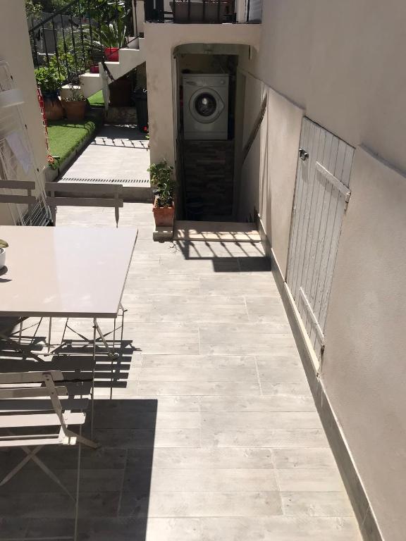 d'une terrasse avec une table et un lave-linge. dans l'établissement Jolie appartement Nice proche mer et aéroport Une chambre plus salon avec cuisine, à Nice