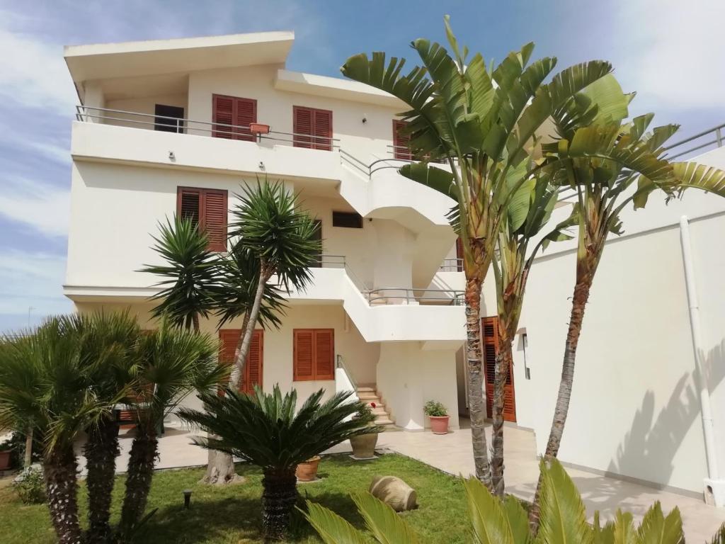 a house with palm trees in front of it at Villa Fiori Beach in Menfi