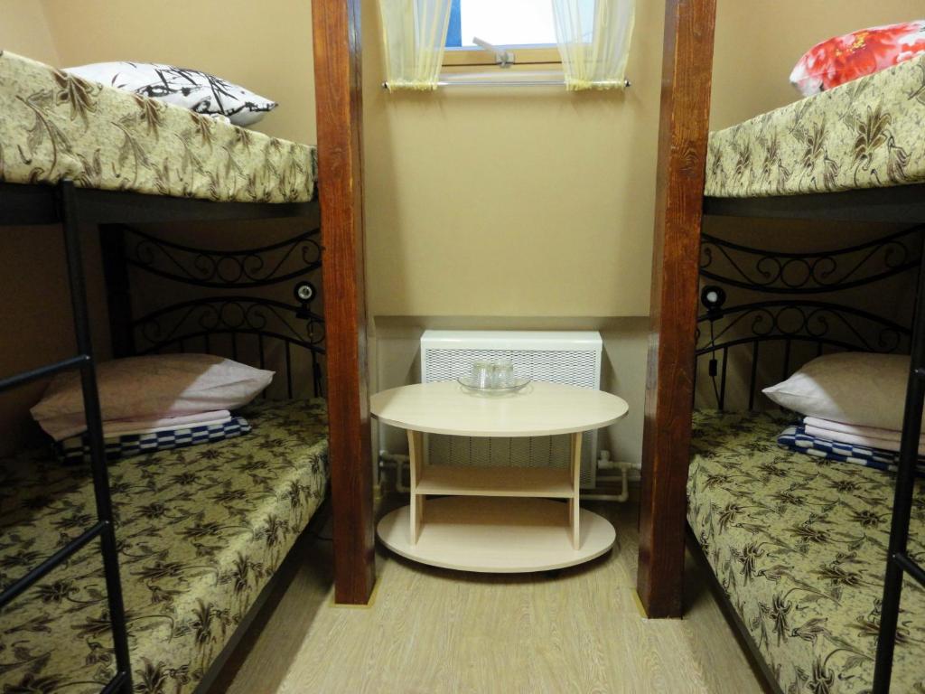 コストロマにあるHostel Littleのテーブルと二段ベッド2台が備わる客室です。