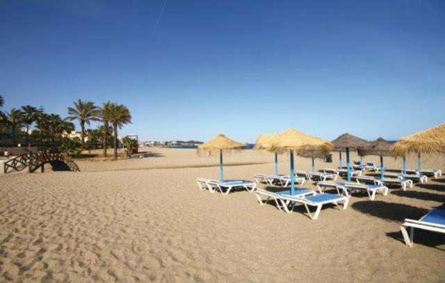 grupa leżaków i parasoli na plaży w obiekcie Málaga, Mijas, La Cala, apartamento vacaciones de ensueño w mieście La Cala de Mijas