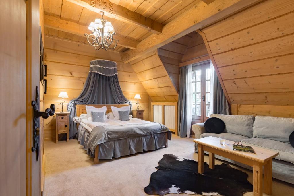 a bedroom with a bed and a couch in a room at Willa Rajka in Zakopane