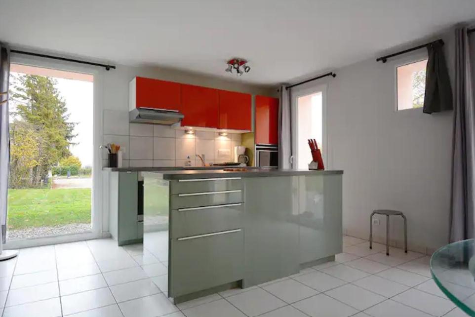 une cuisine avec des placards rouges et un comptoir gris dans l'établissement Le Petit Atelier, à Excenevex