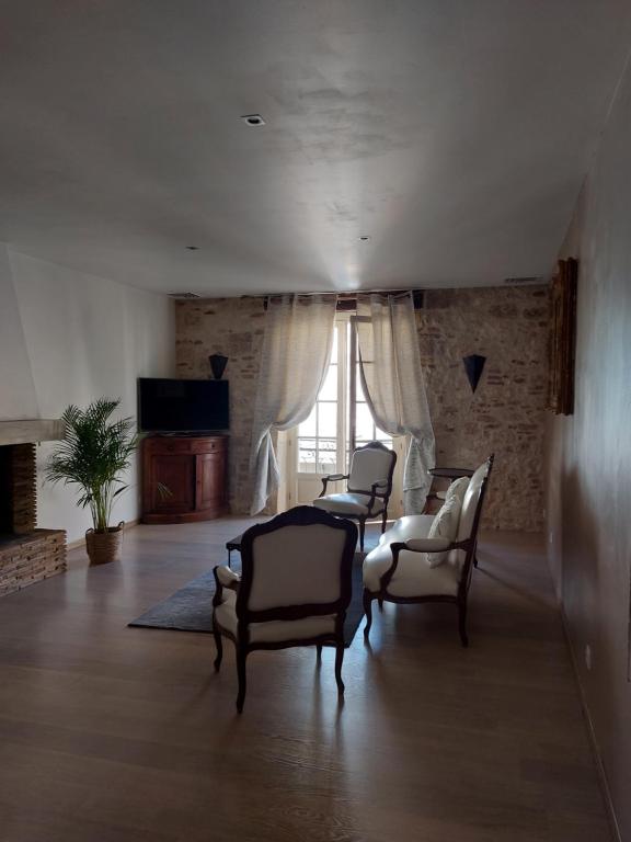 a living room with three chairs and a window at L'Appartement de la MAISON BLEUE in Villeréal