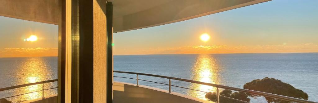 By the Sea 3 - Luxurious Residence في دوريس: شرفة مطلة على المحيط وقت الغروب