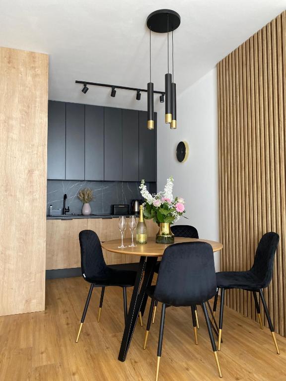 kuchnia i jadalnia ze stołem i krzesłami w obiekcie P&A APARTAMENT w Gąskach