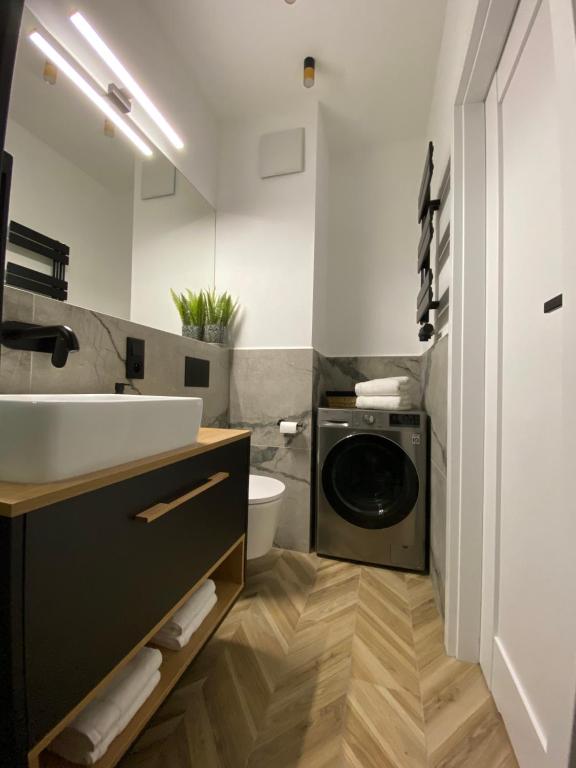 łazienka z umywalką i pralką w obiekcie P&A APARTAMENT w Gąskach