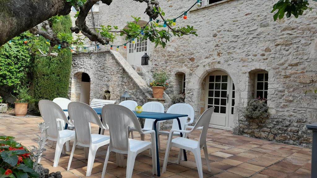 una mesa y sillas en un patio con un edificio en Le jardin, en Saint-Martin-dʼArdèche