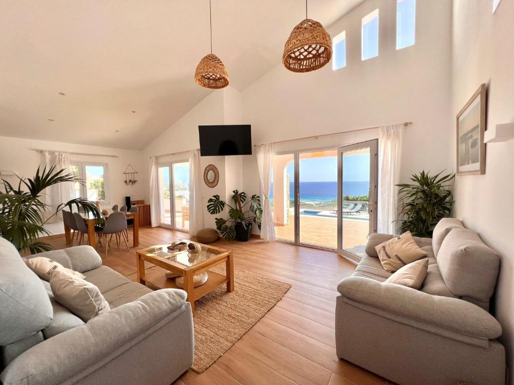 a living room with two couches and a view of the ocean at Villa Ona in Son Bou