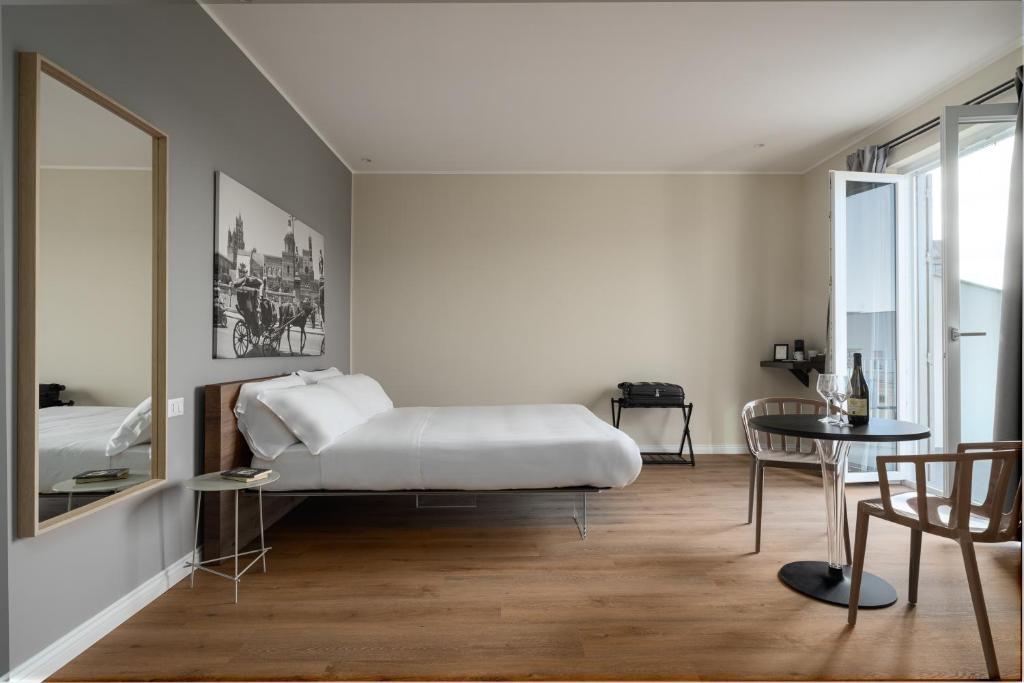 sypialnia z łóżkiem, stołem i lustrem w obiekcie Attico 37 - Queen room con terrazza privata w mieście Palermo