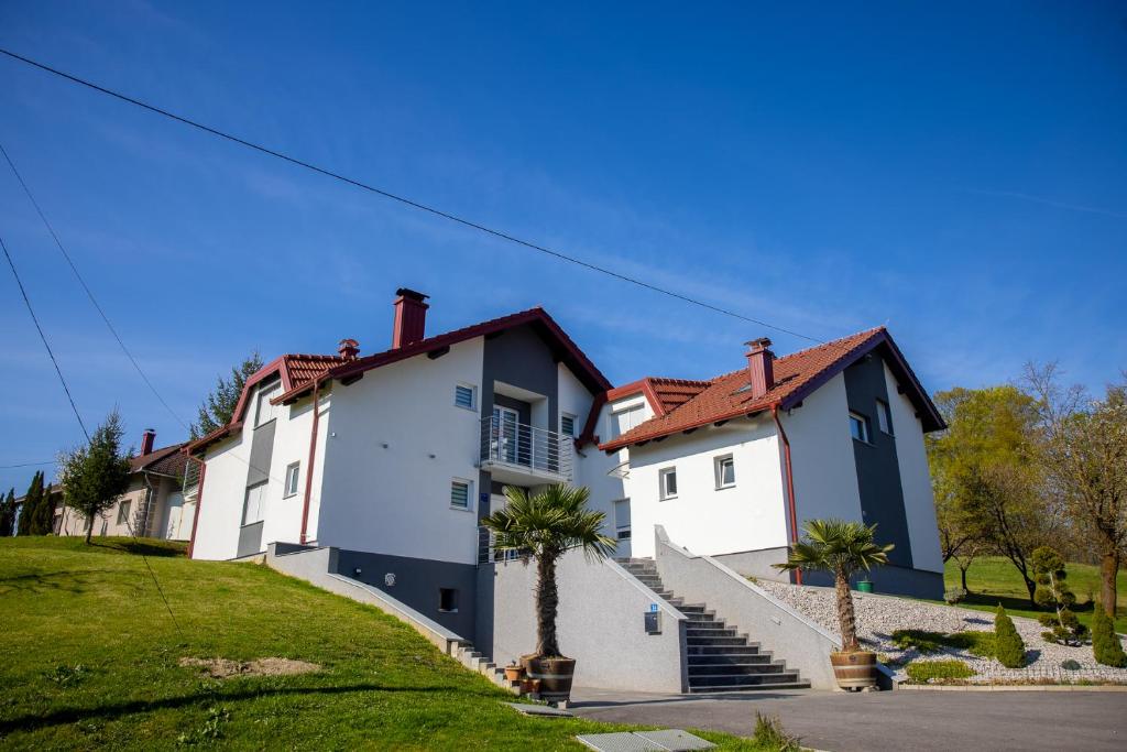 a row of white houses with palm trees in front at Apartmani San Martin in Sveti Martin na Muri