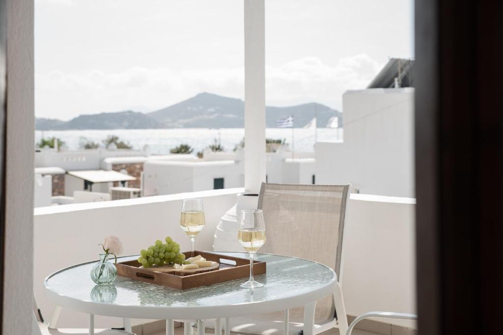 a table with two glasses of wine on a balcony at Sea View Casa in Naxos Chora