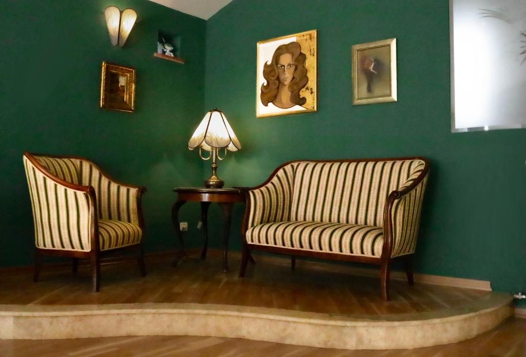 duas cadeiras e uma mesa num quarto com paredes verdes em Luxury Spalato Garden em Split