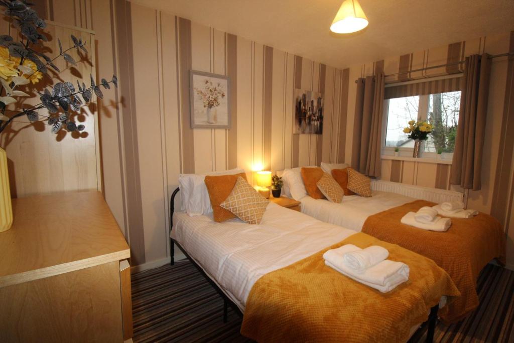 a hotel room with two beds and a window at Aspley House in Sutton in Ashfield