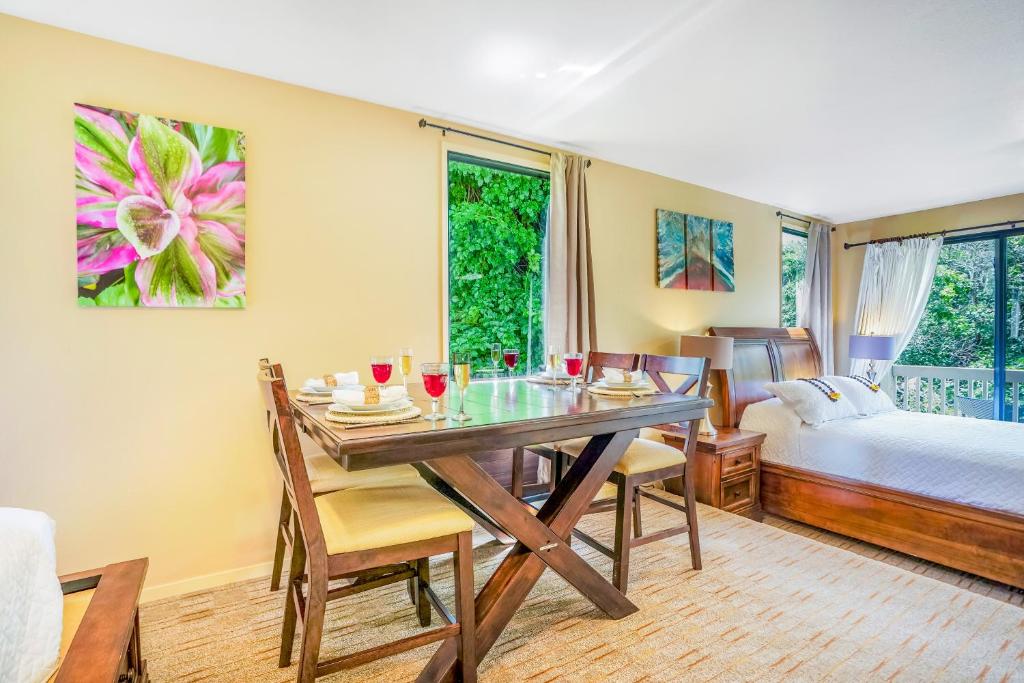 a dining room with a table and a bed at Hale Moi #103A in Princeville