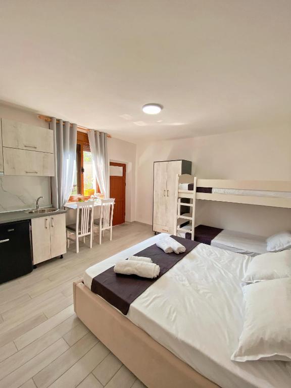 a bedroom with a large bed and a kitchen at Sunny guest house in Vlorë
