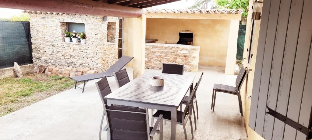 una mesa y sillas en un patio en L'agréable maison du Verdon, en Gréoux-les-Bains