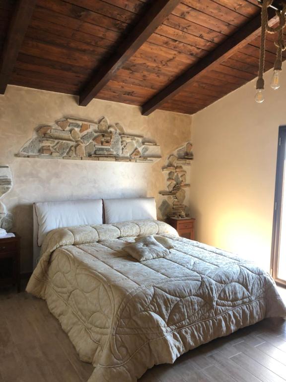 雷焦卡拉布里亞的住宿－Il casale degli aragonesi，一间卧室设有一张带木制天花板的大床