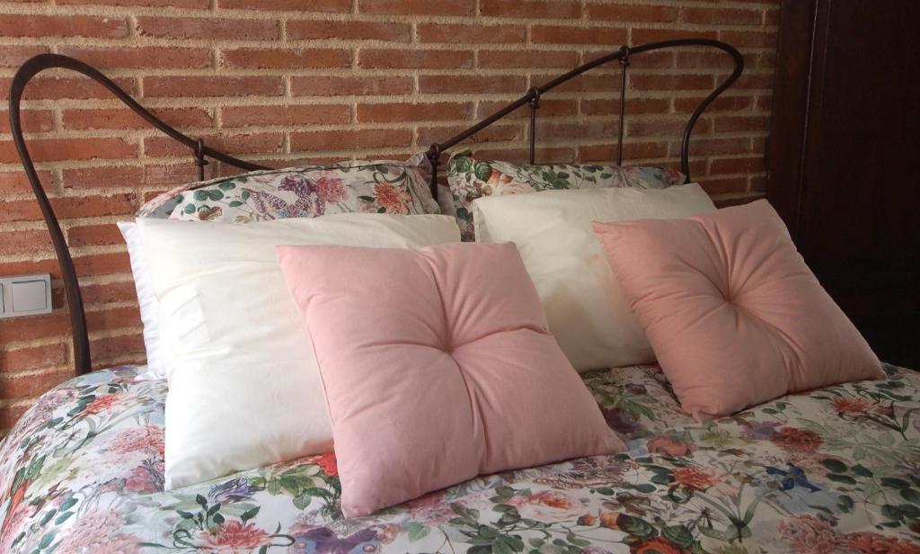 Lets Holidays Tossa de Mar Romantic Apartment في توسا ذي مار: سرير مع وسادتين ورديتين عليه