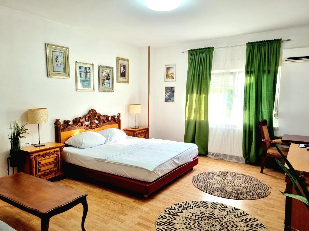 1 dormitorio con 1 cama grande y cortinas verdes en Rooms Villa Luigi, en Pančevo