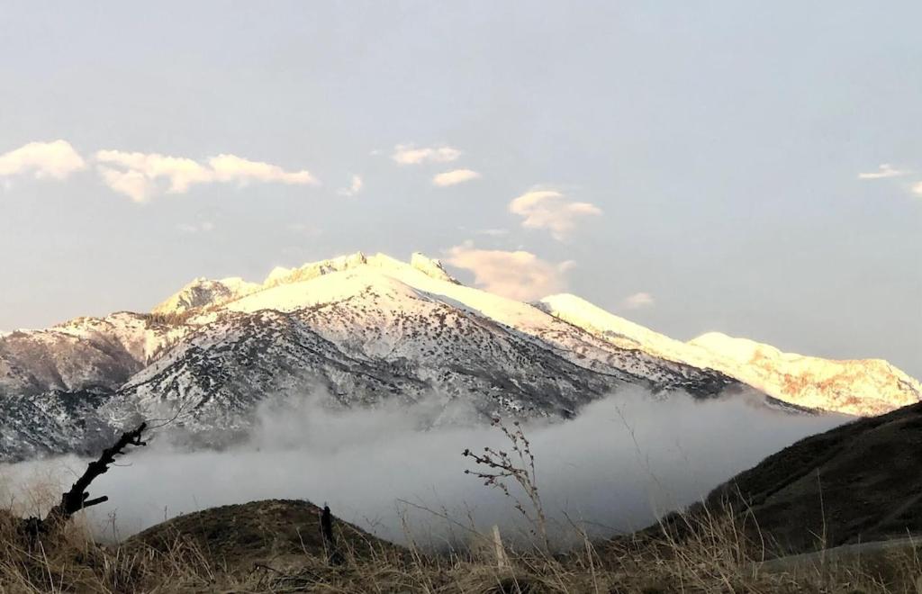 una montaña cubierta de nieve con nubes delante de ella en Stay & Play in the Little Switzerland of Utah!!! en Draper