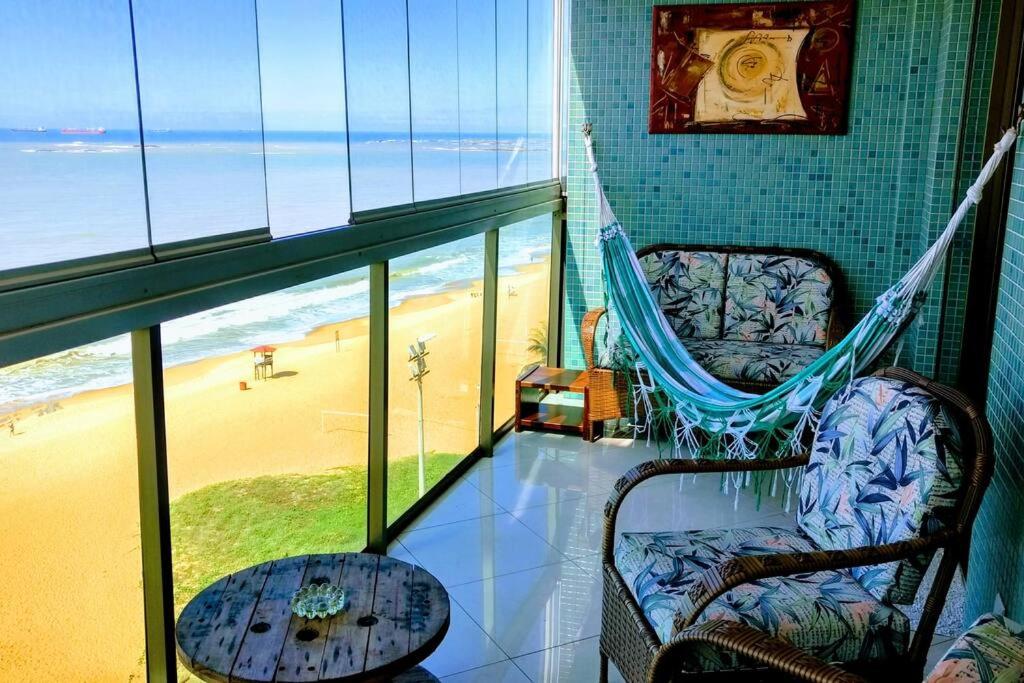 a balcony with a hammock and a view of the beach at Cristal Residence in Vila Velha