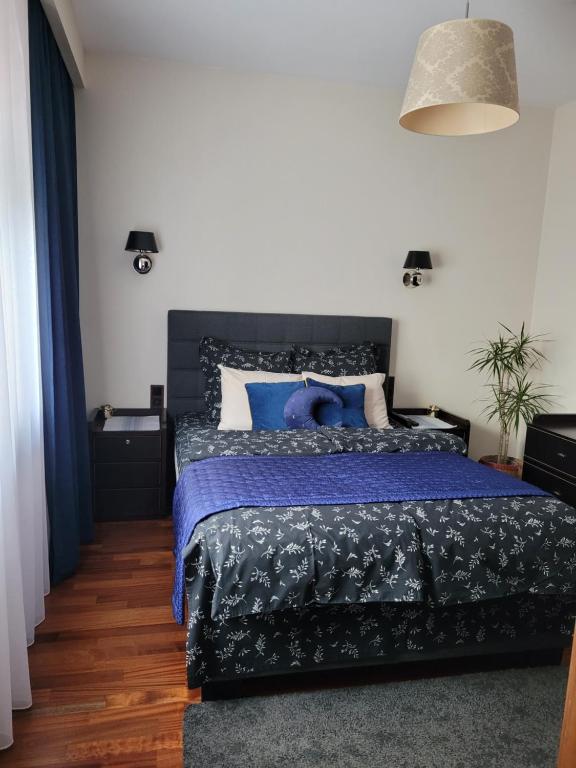 a bedroom with a bed with a blue comforter at Apartament LUNA Francuska Park in Katowice
