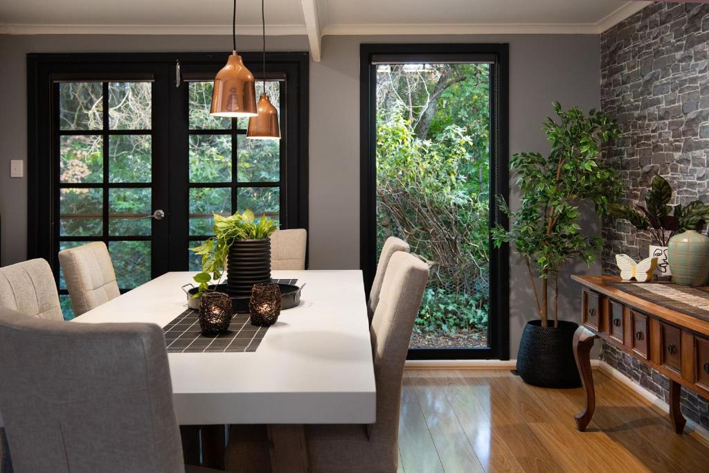 a dining room with a white table and chairs at East St Spa House in Daylesford