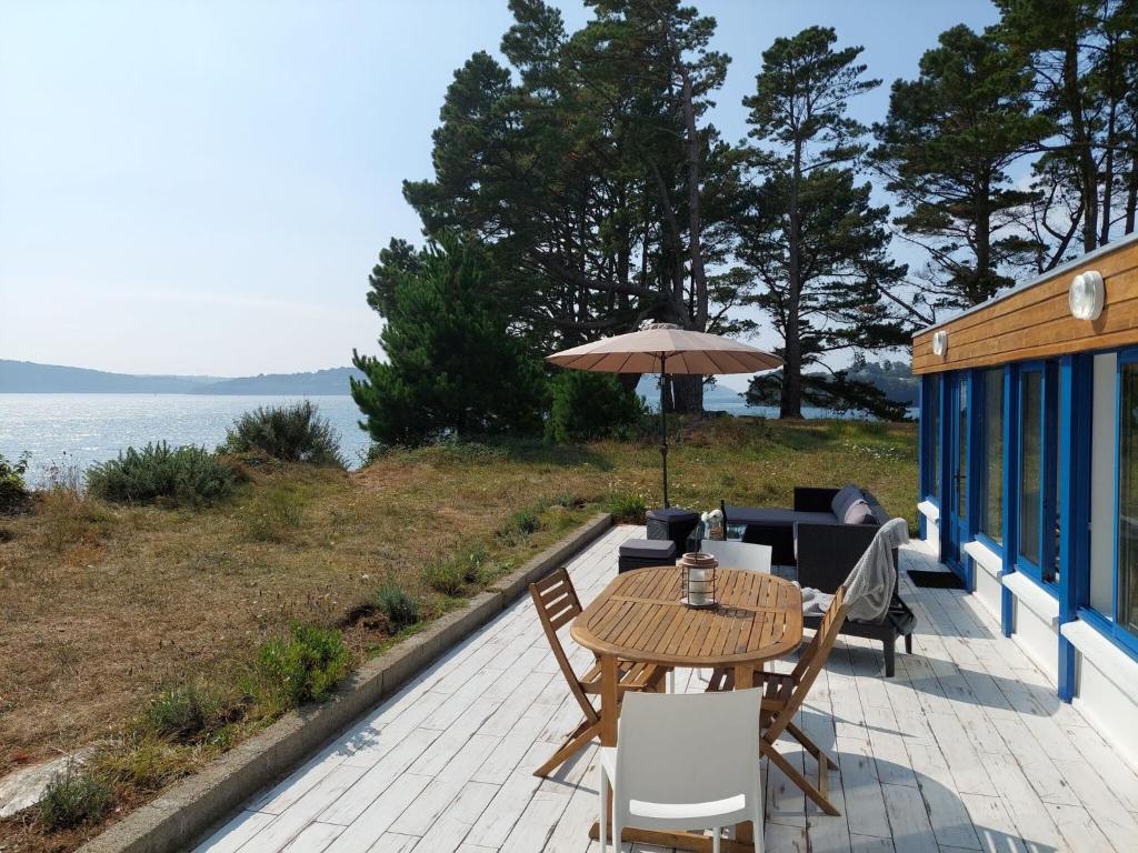 a patio with a table and chairs and an umbrella at Holiday home in a secluded location surrounded by the sea, Hanvec in Hanvec