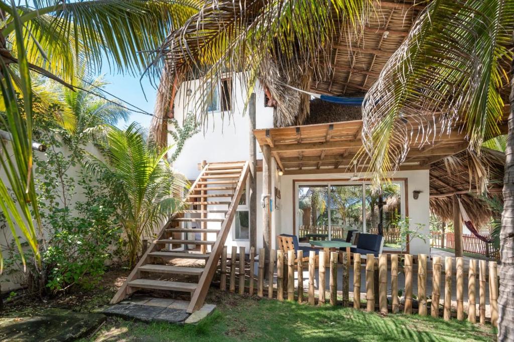 a staircase leading up to a house with a palm tree at Zoah Surf, El Paredón in El Paredón Buena Vista