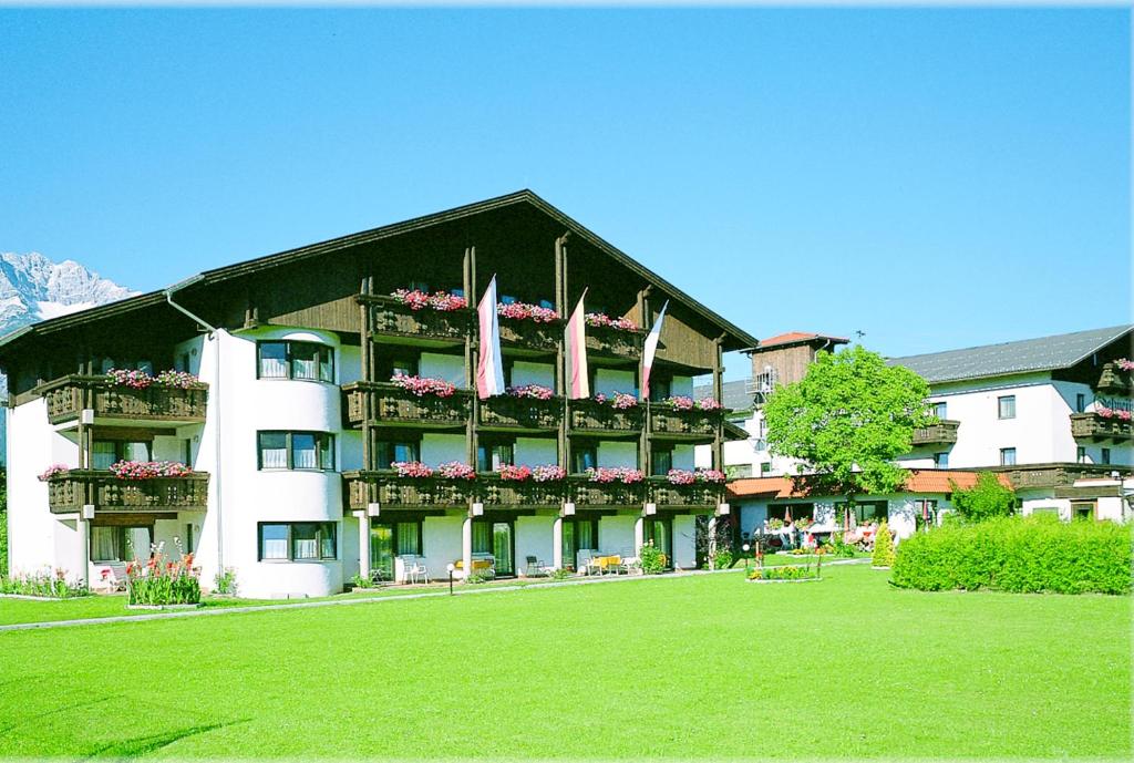 ein großes Gebäude mit Blumen auf den Balkonen in der Unterkunft Hotel Edelweiss in Innsbruck