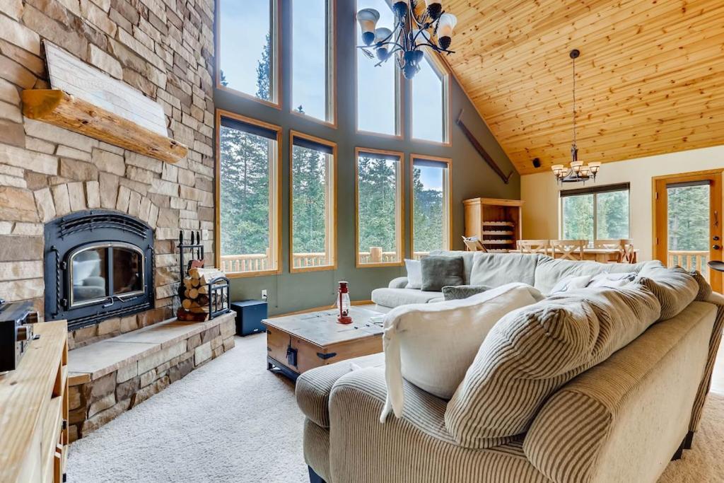 un soggiorno con divano e camino in pietra di Private Retreat with Hot Tub and Game Room - Mountain Vista ad Alma