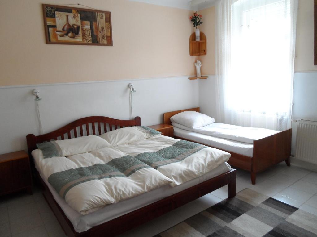 a bedroom with two beds and a window at Garden Szivárvány utca 39 Superior Vendégház in Szeged