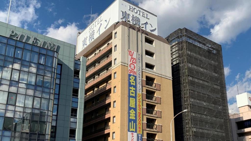 Un palazzo alto con un cartello sopra. di Toyoko Inn Shin-yokohama Ekimae Shinkan a Yokohama