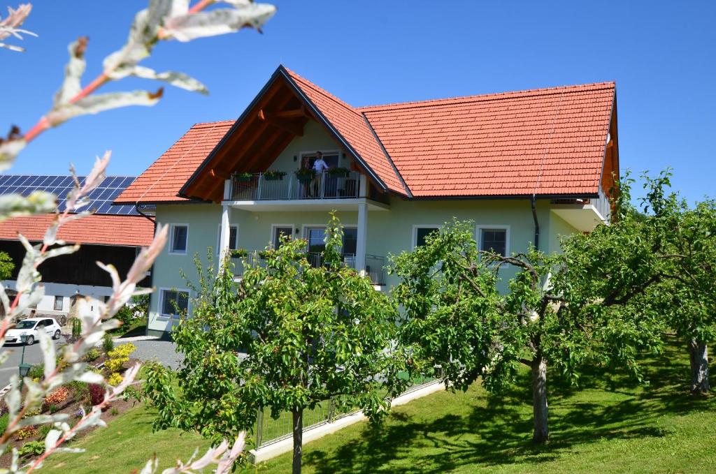 una casa con techo rojo y árboles en Weingut Zirngast en Leutschach