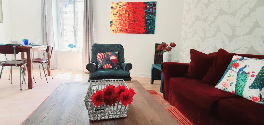 ein Wohnzimmer mit einem roten Sofa und einem Tisch in der Unterkunft Artistique in Sillé-le-Guillaume