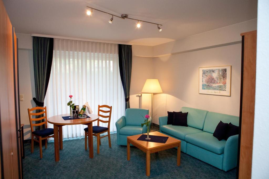 ein Wohnzimmer mit einem Sofa und einem Tisch in der Unterkunft Landhotel Imhof in Neuhof