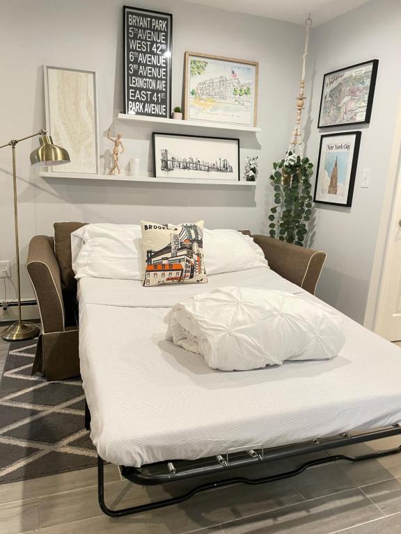 duże łóżko w pokoju z białą pościelą w obiekcie Modern apartment with parking & quick ride to Manhattan w mieście Cedar Manor