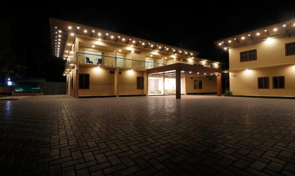 a large building with lights on it at night at Treebo Grand Vistara Airport Suites in Cochin