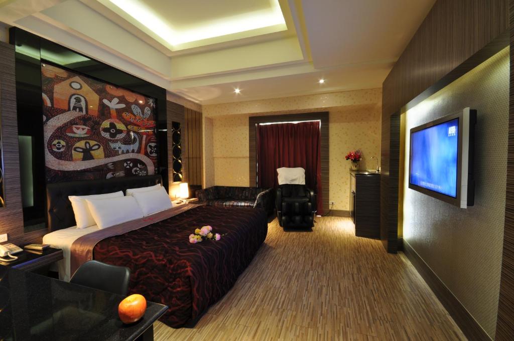 采岩汽車旅館 في تايتشونغ: غرفة فندقية بسرير وتلفزيون بشاشة مسطحة
