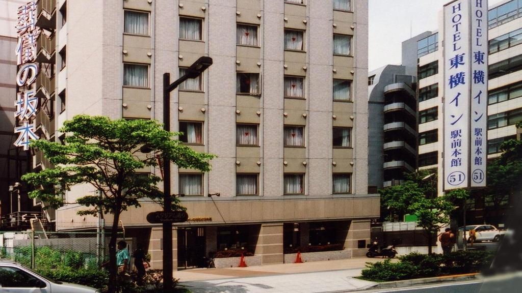 duży budynek z znakiem przed nim w obiekcie Toyoko Inn Shin-yokohama Ekimae Honkan w mieście Jokohama