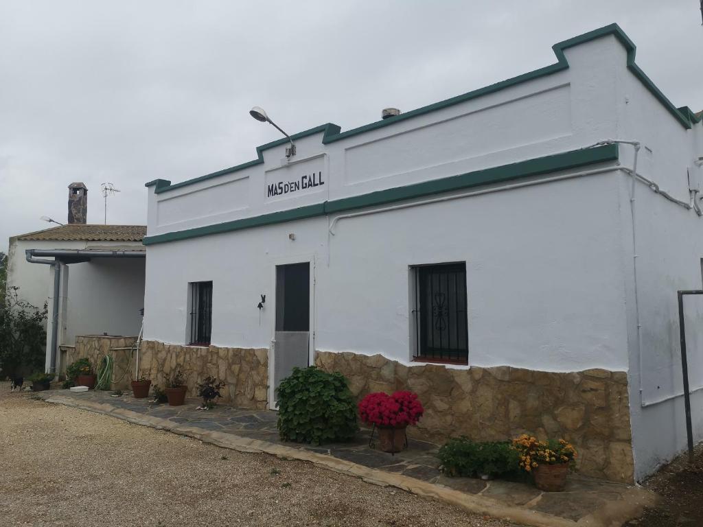 een wit gebouw met planten ervoor bij Casa Rural Masia d'en Gall in L'Aldea