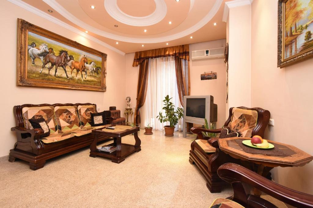 a living room with two couches and a tv at Guest house YEREVAN in Yerevan