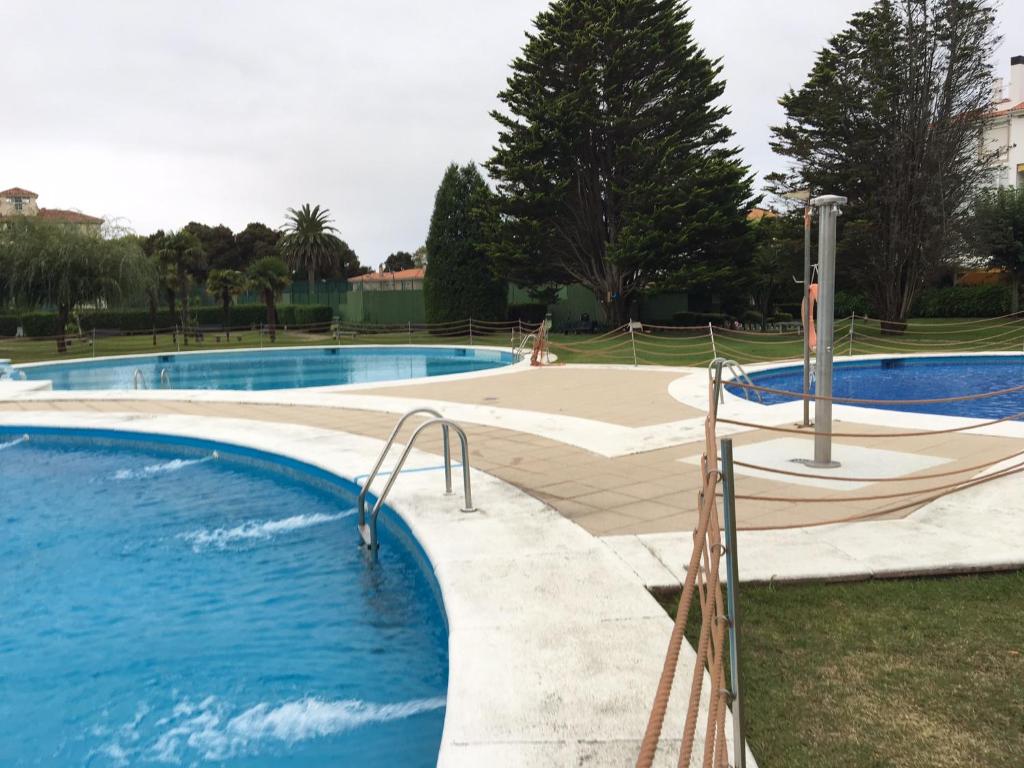 2 piscinas con toboganes en un parque en Apartamento en La Toja de tres habitaciones, en O Grove