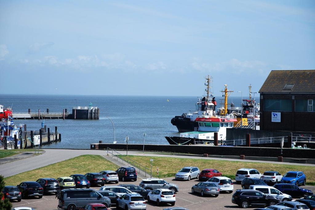 a parking lot with cars parked in front of a boat at Am Seedeich 7 SE10 Seesicht in Cuxhaven