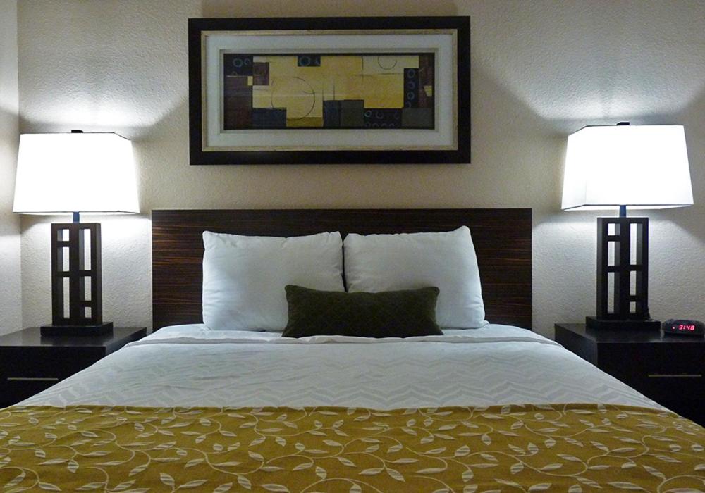 a bedroom with a bed with two lamps on it at Waterfront Hotel and Marina in Johnsburg