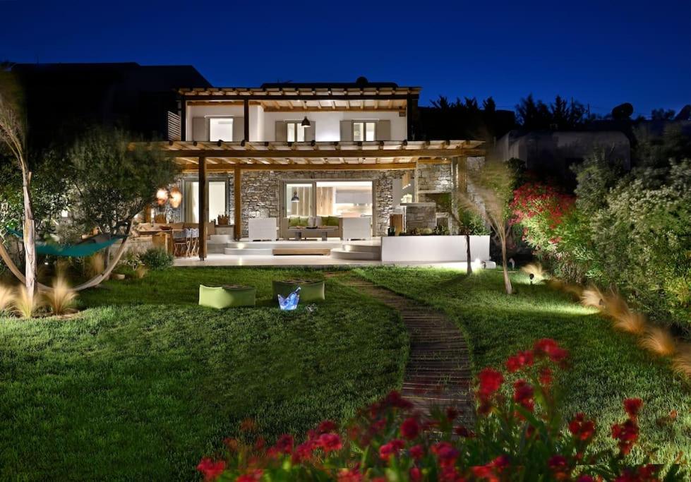 a house with a garden in front of it at Beachfront Villa Kalafatis by Aesthia Estate in Kalafatis