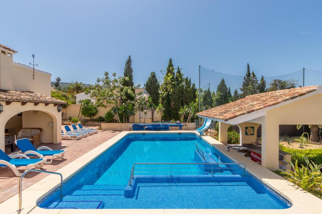 a swimming pool in a villa with a house at Casa Henry in Jávea