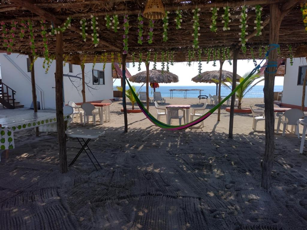 un parque infantil en la playa con sillas y sombrillas en Cabañas Alta Mar en Guayabas