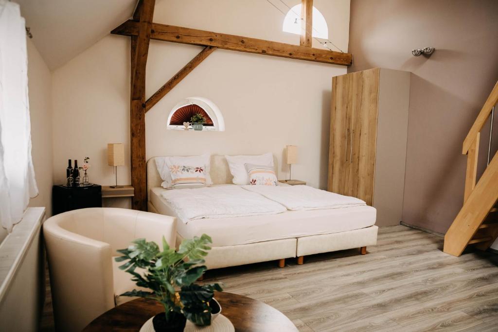 een slaapkamer met een bed, een stoel en een tafel bij Altstadt-Residenz Manz in Wachenheim an der Weinstraße