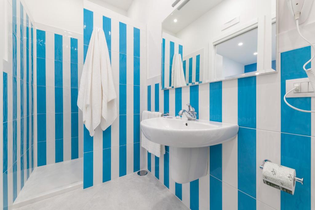 Łazienka z umywalką i niebiesko-białymi paskami. w obiekcie Blue Coral Suite B&B w Sorrento
